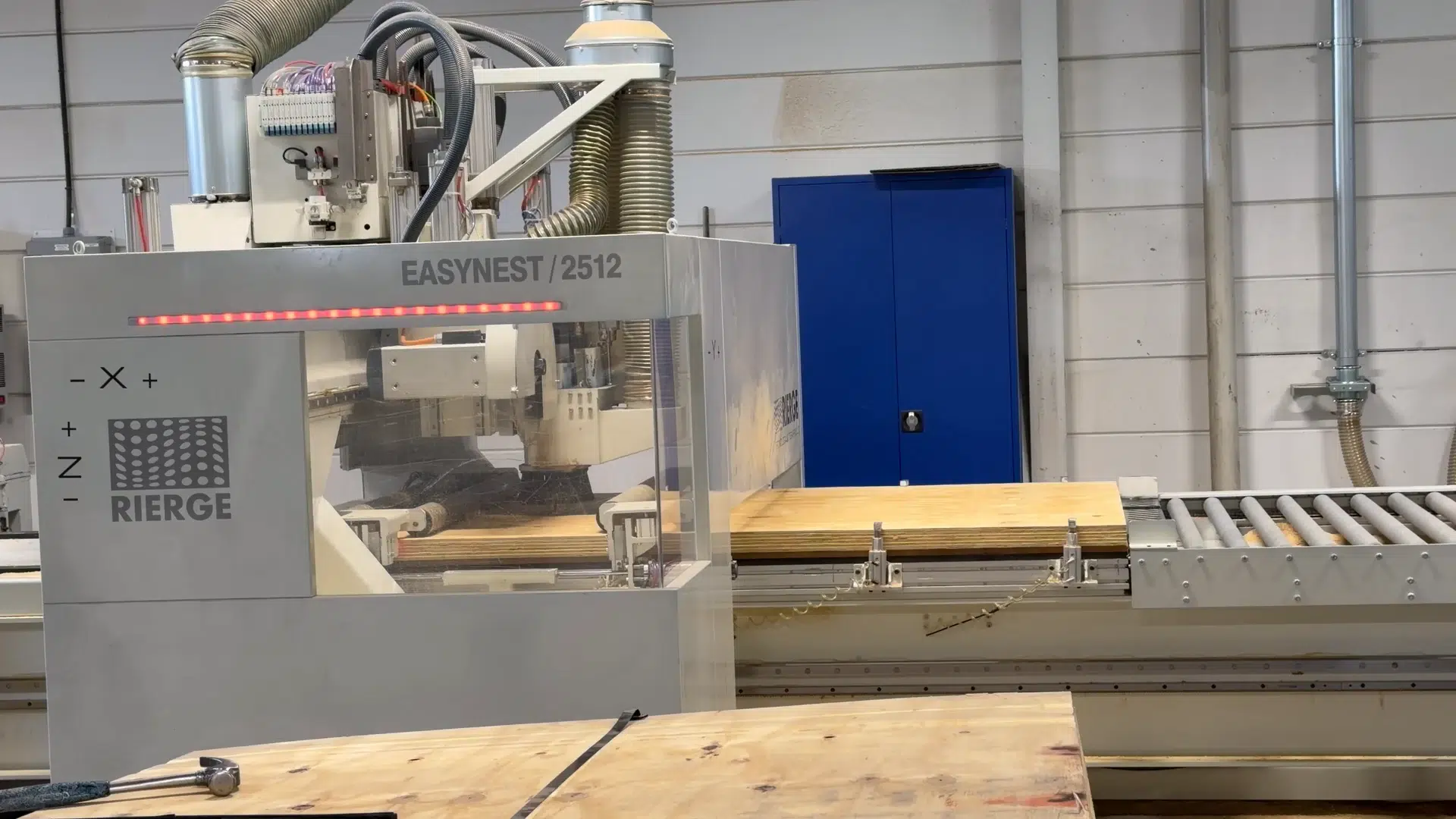 GLF's Rierge EasyNest CNC machine with plywood on the roller conveyor in Genarp.